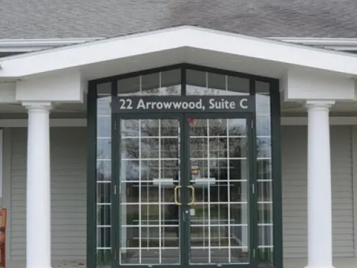 The glass entrance of the practice, lettered 22 Arrowwood, Suite C.